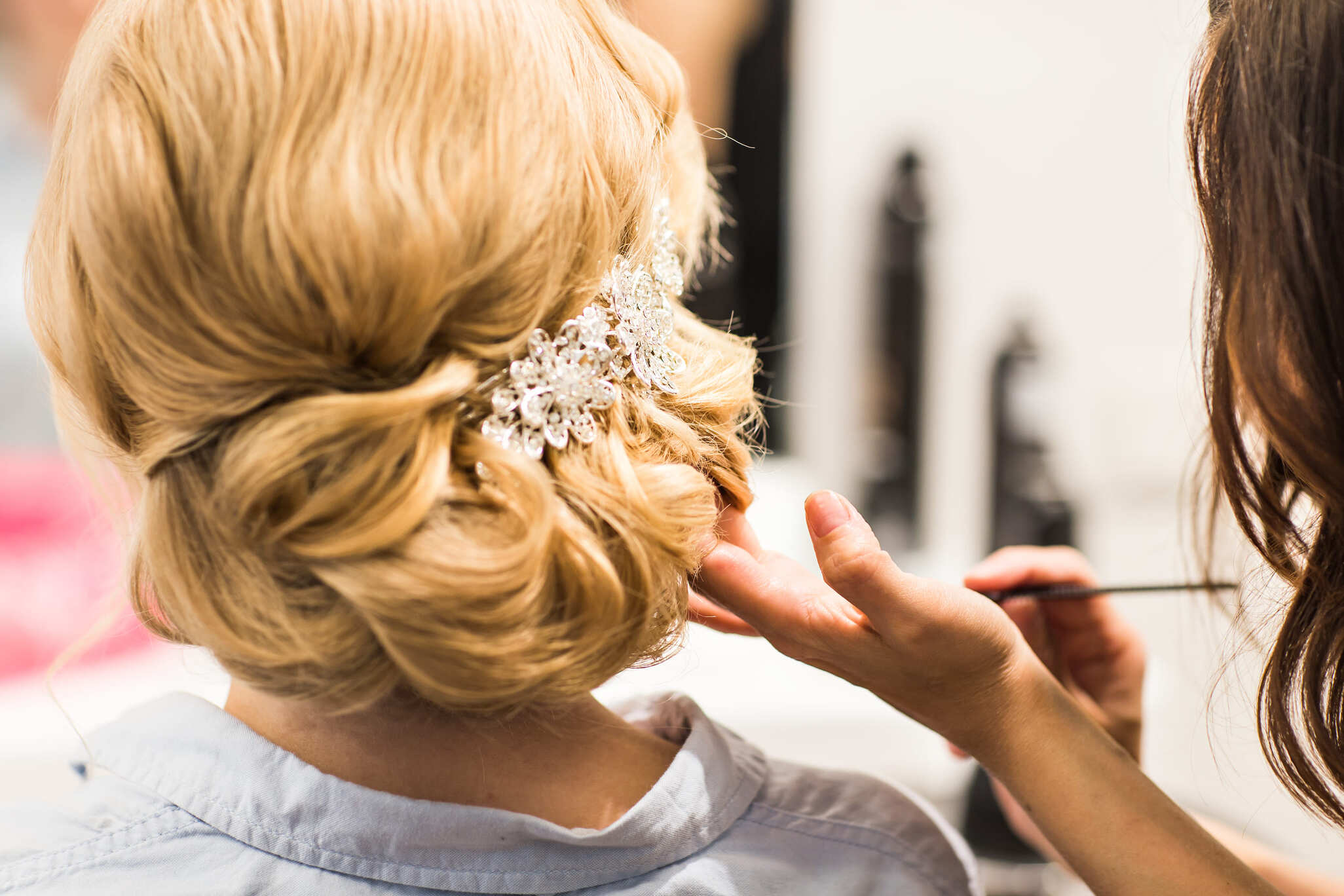 Detalle de un peinado de boda con accesorio brillante en el cabello rubio de una persona.